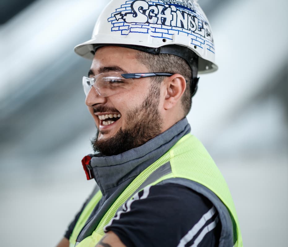 Homem sorrindo enquanto utiliza equipamentos de EPI