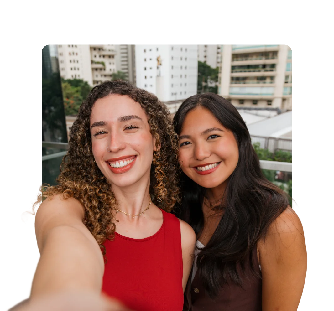 Duas jovens mulheres sorrindo enquanto fazem uma selfie