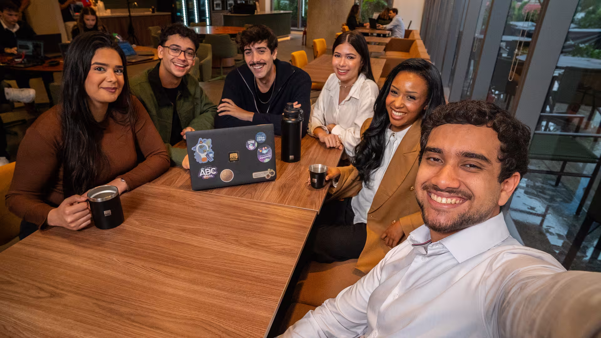 Todos os estagiários tirando um selfie na mesa do escritório