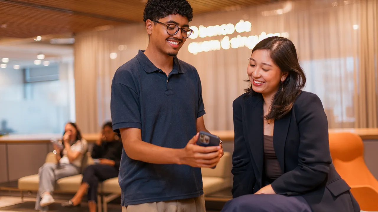 Jovem mostrando o celular para estagiária