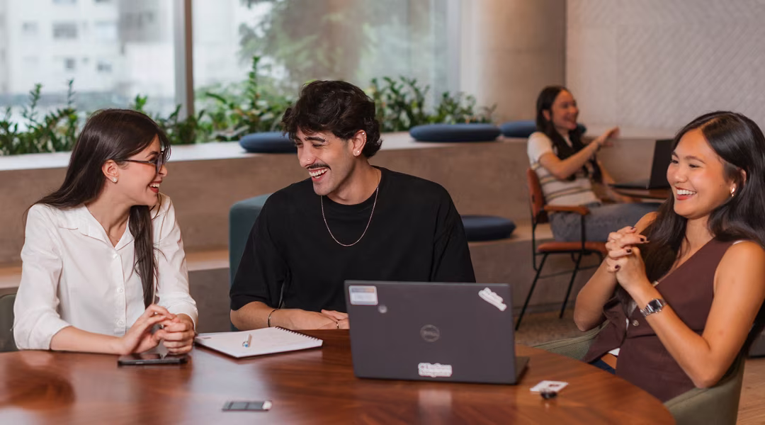 Estagiários sentados em uma mesa redonda no escritório