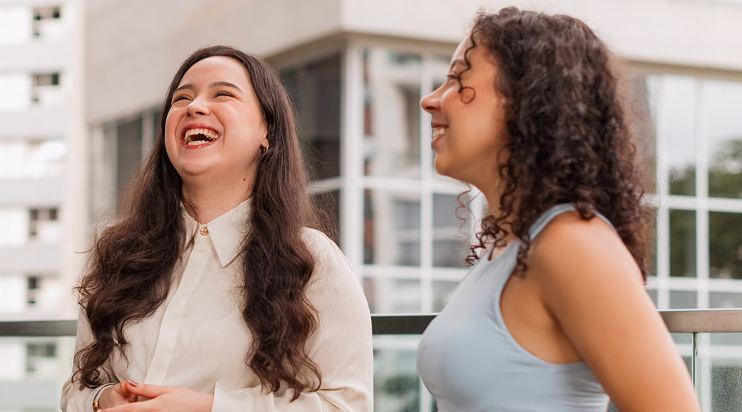Estagiárias conversando e sorrindo