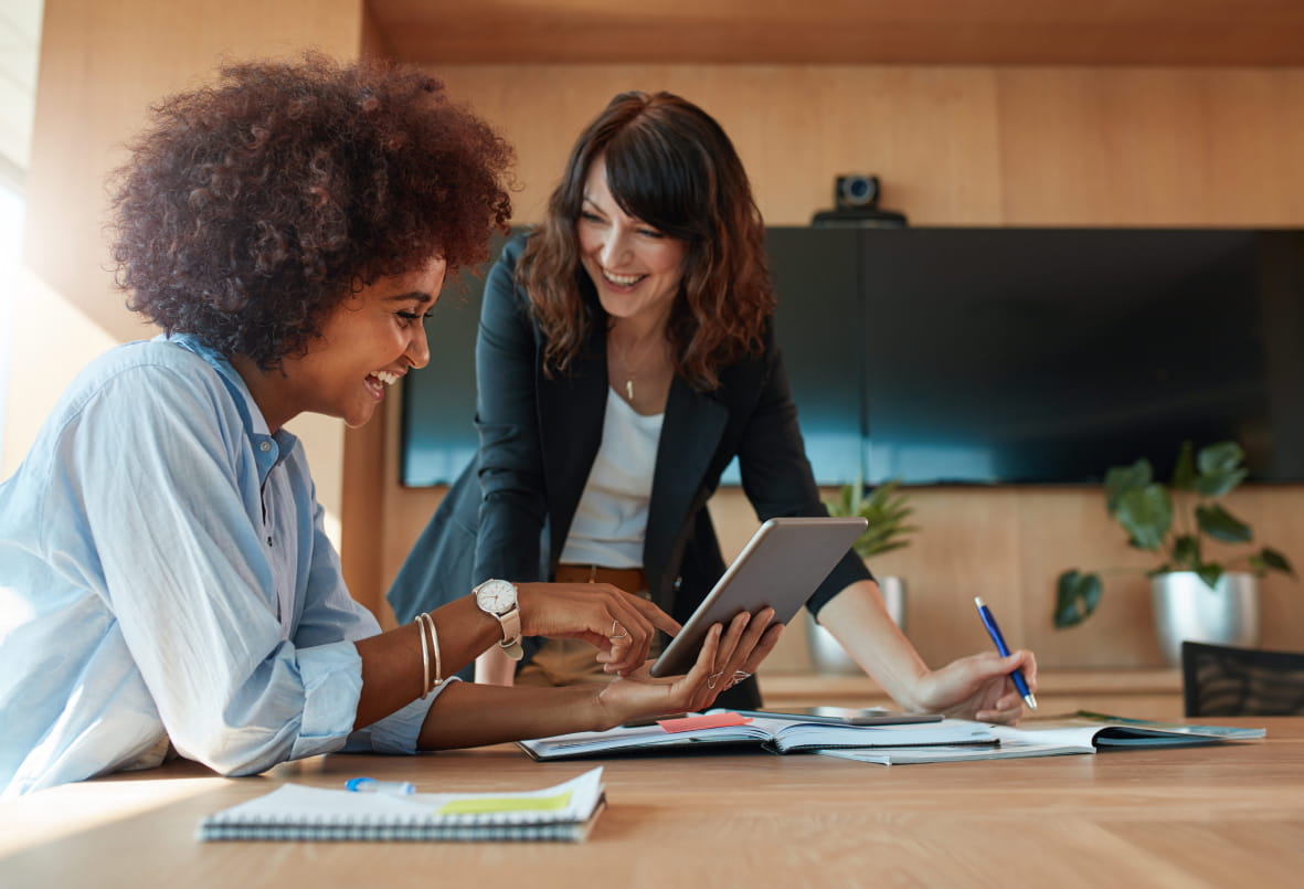 Duas mulheres em um escritório conversando sobre um projeto