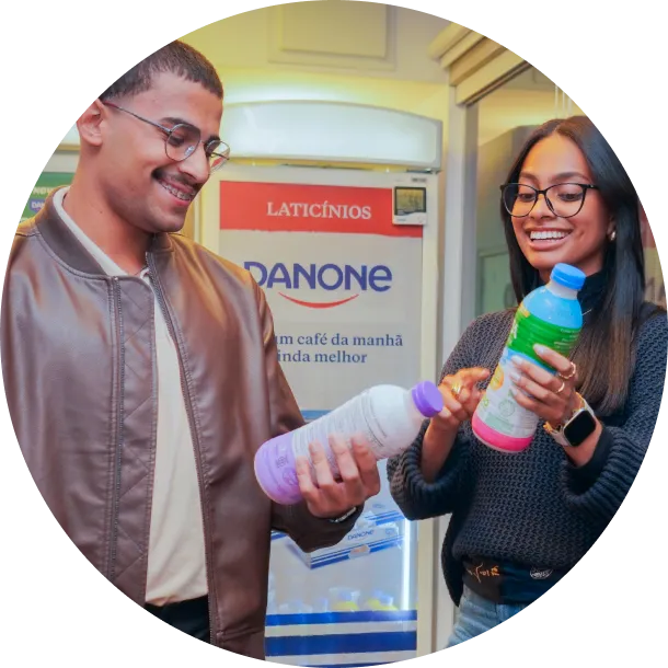 Jovens sorrindo e segurando garrafa de Danone