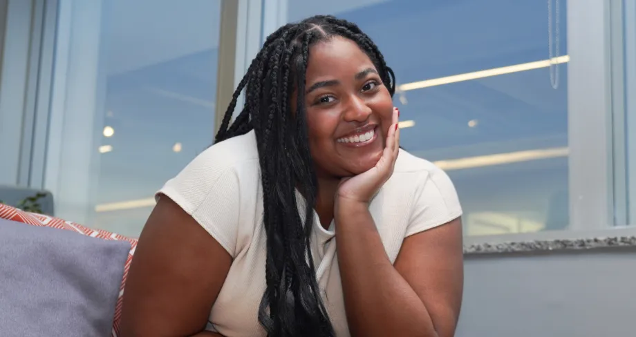 Jovem negra sorrindo sentado no sofá