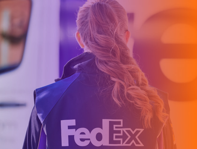 Mulher de costas com uniforme FedEx olhando para um caminhão