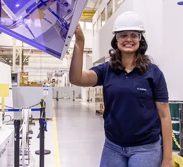 Estagiária sorrindo enquanto trabalha na fábrica
