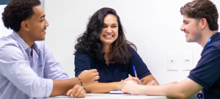 3 estagiários conversando no escritório