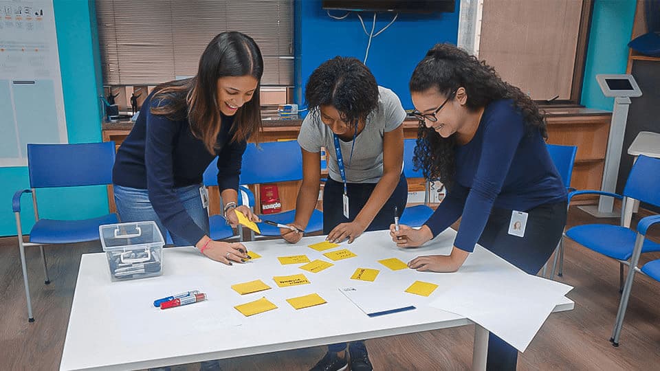 Mulheres jovens no escritório escrevendo em post-it