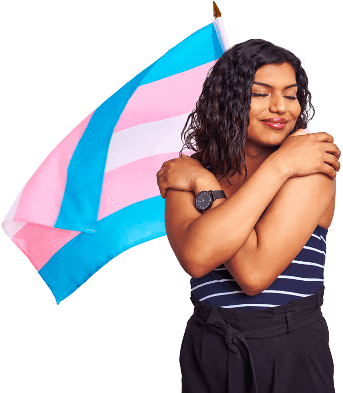 Mulher abraçando a si mesma em frente a uma bandeira azul e rosa
