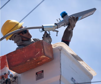 Trabalhador mexendo em cabo do poste