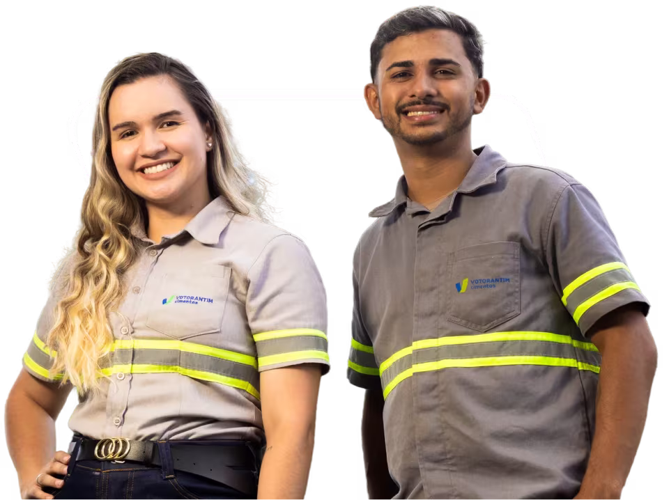 Jovem mulher e jovem homem sorrindo, com uniformes da Votorantim Cimentos