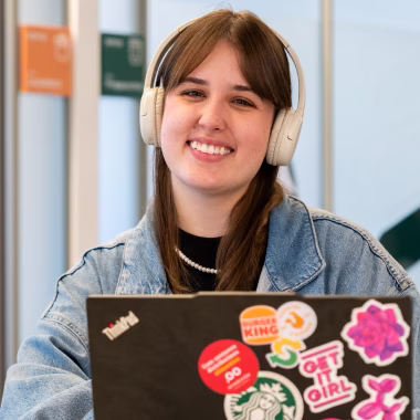Estagiários utilizando headphone e notebook