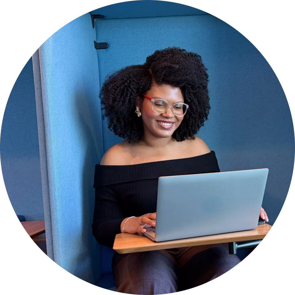 Mulher negra de óculos usando o notebook no escritório da Zurich