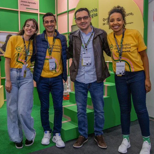 Female employees and director of the Companhia de Estágios at the company's booth at a fair