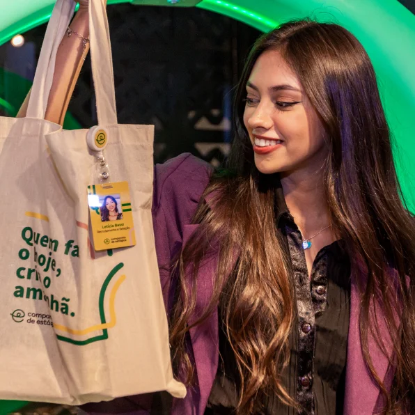 Joven sosteniendo una ecobolsa de la Companhia de Estágios