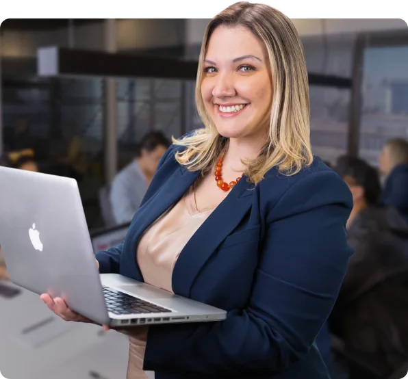 Estagiária sorrindo enquanto usa o computador