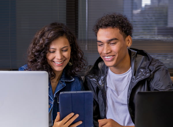 Dos jóvenes en la oficina de la Companhia de Estágios usando la computadora