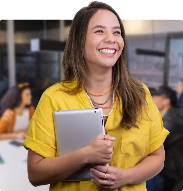 Joven sonriendo mientras sostiene una tablet