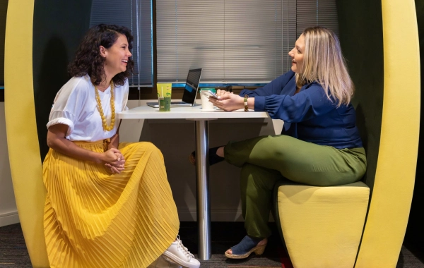 Two Young Women Talking and Working in a Beautiful Office